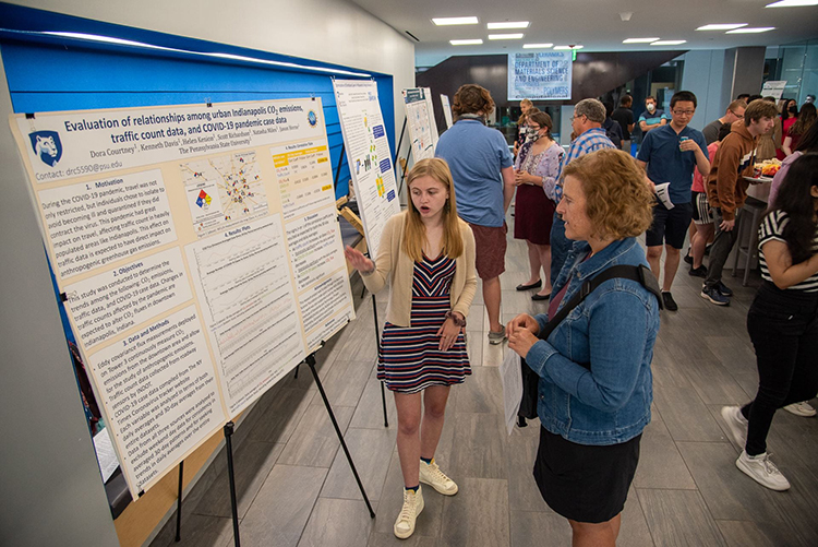 Student presenting poster at Climate Science REU Symposium